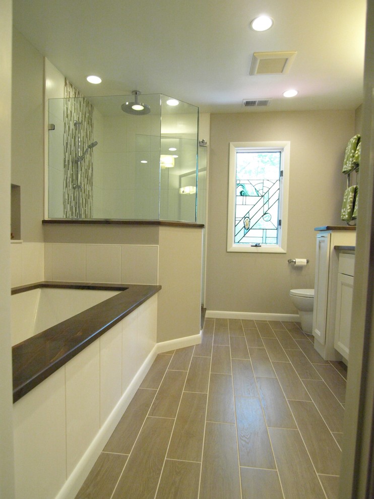 На фото: главная ванная комната среднего размера в стиле неоклассика (современная классика) с фасадами с утопленной филенкой, белыми фасадами, ванной в нише, угловым душем, серыми стенами, полом из ламината, серым полом, душем с распашными дверями, унитазом-моноблоком, бежевой плиткой, керамической плиткой, врезной раковиной и столешницей из гранита с