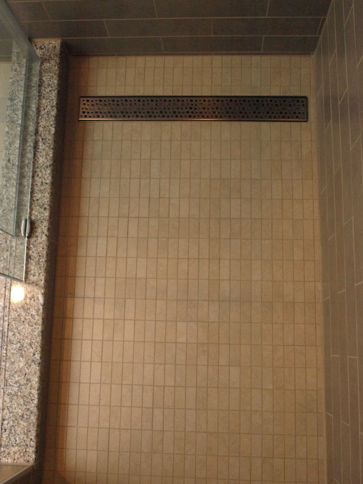 Example of a large transitional master beige tile and ceramic tile porcelain tile and beige floor bathroom design in Newark with flat-panel cabinets, brown cabinets, a two-piece toilet, beige walls, an undermount sink and granite countertops