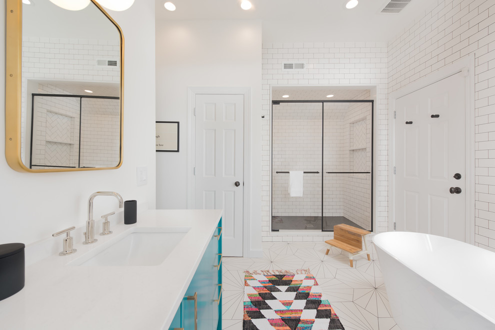 Пример оригинального дизайна: большая главная ванная комната в современном стиле с плоскими фасадами, синими фасадами, отдельно стоящей ванной, белой плиткой, плиткой кабанчик, врезной раковиной, столешницей из искусственного кварца и душем с распашными дверями