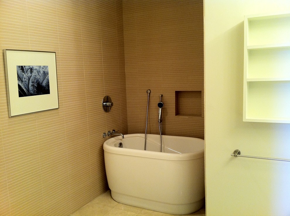 Cette image montre une petite salle de bain principale design avec une baignoire indépendante, un carrelage beige et un mur beige.