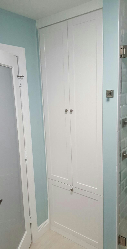 Réalisation d'une salle de bain tradition avec un placard à porte shaker et des portes de placard blanches.