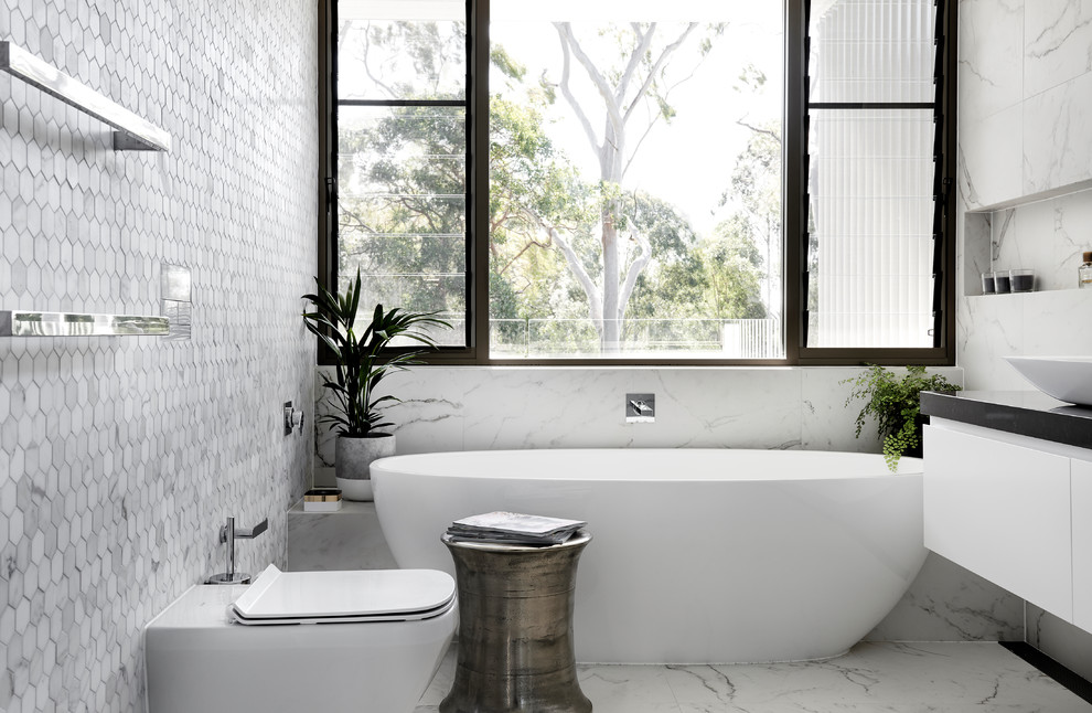 Пример оригинального дизайна: ванная комната среднего размера в современном стиле с плоскими фасадами, белыми фасадами, отдельно стоящей ванной, унитазом-моноблоком, разноцветной плиткой, металлической плиткой, разноцветными стенами, настольной раковиной, столешницей из дерева, разноцветным полом и мраморным полом
