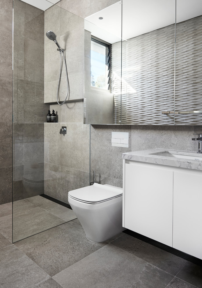 Стильный дизайн: ванная комната среднего размера в современном стиле с плоскими фасадами, белыми фасадами, открытым душем, унитазом-моноблоком, серой плиткой, плиткой из листового камня, серыми стенами, полом из сланца, накладной раковиной, мраморной столешницей, серым полом и открытым душем - последний тренд