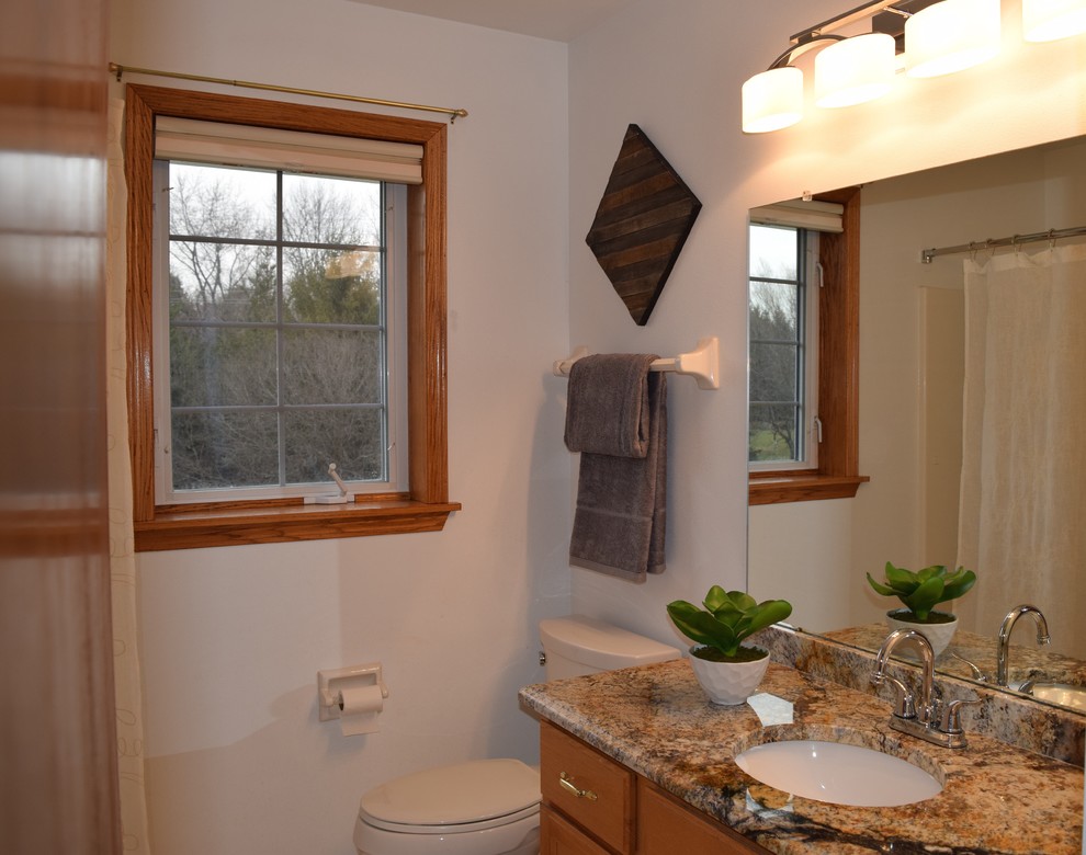 Kleines Klassisches Duschbad mit hellbraunen Holzschränken, Wandtoilette mit Spülkasten, weißer Wandfarbe, Unterbauwaschbecken und Granit-Waschbecken/Waschtisch in Milwaukee