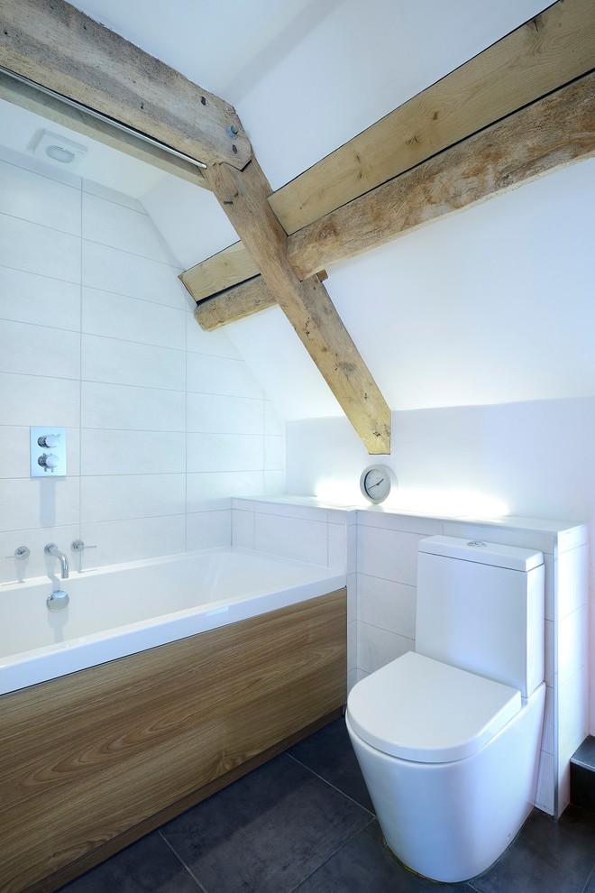 Inspiration for a medium sized rural bathroom in Other with a built-in bath, a built-in shower, a two-piece toilet, white tiles, white walls and black floors.