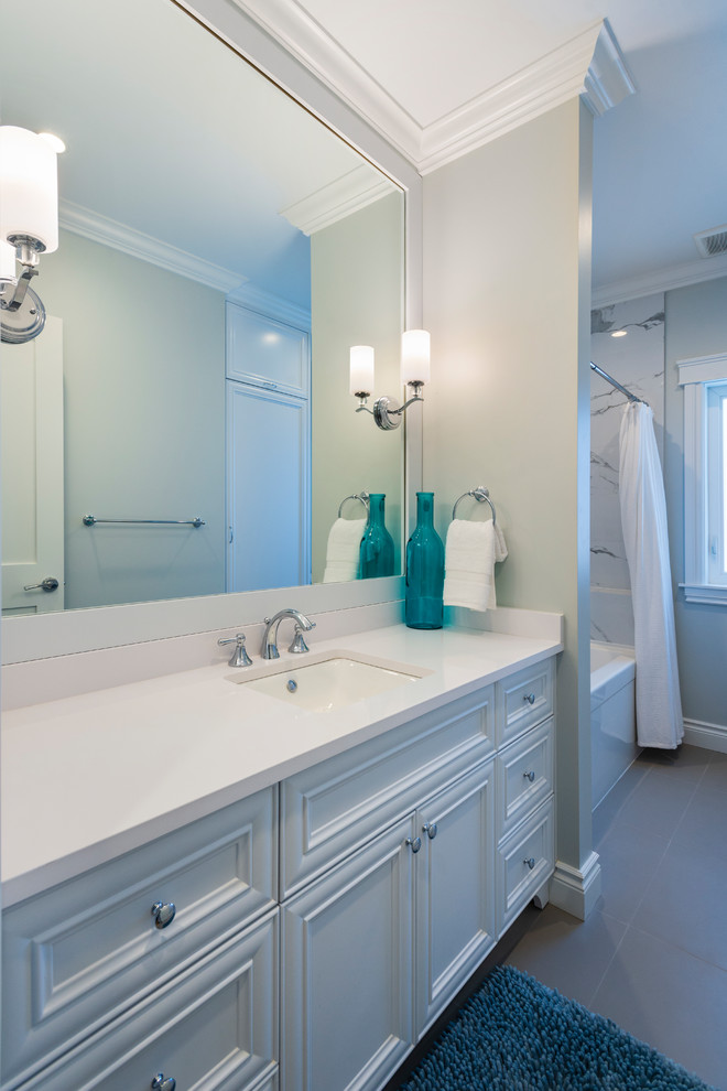 Example of a mid-sized classic 3/4 gray tile and marble tile porcelain tile and gray floor bathroom design in Vancouver with recessed-panel cabinets, white cabinets, gray walls, an undermount sink, quartz countertops and white countertops
