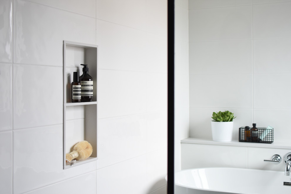 Alcove shower - mid-sized scandinavian master gray tile and porcelain tile porcelain tile and multicolored floor alcove shower idea in Montreal with flat-panel cabinets, light wood cabinets, gray walls, a trough sink, a hinged shower door and white countertops