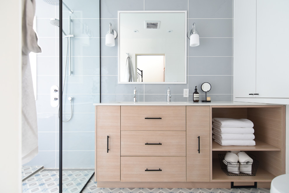 Exemple d'une douche en alcôve principale scandinave en bois clair de taille moyenne avec un placard à porte plane, un carrelage gris, des carreaux de porcelaine, un mur gris, un sol en carrelage de porcelaine, une grande vasque, un sol multicolore, une cabine de douche à porte battante et un plan de toilette blanc.
