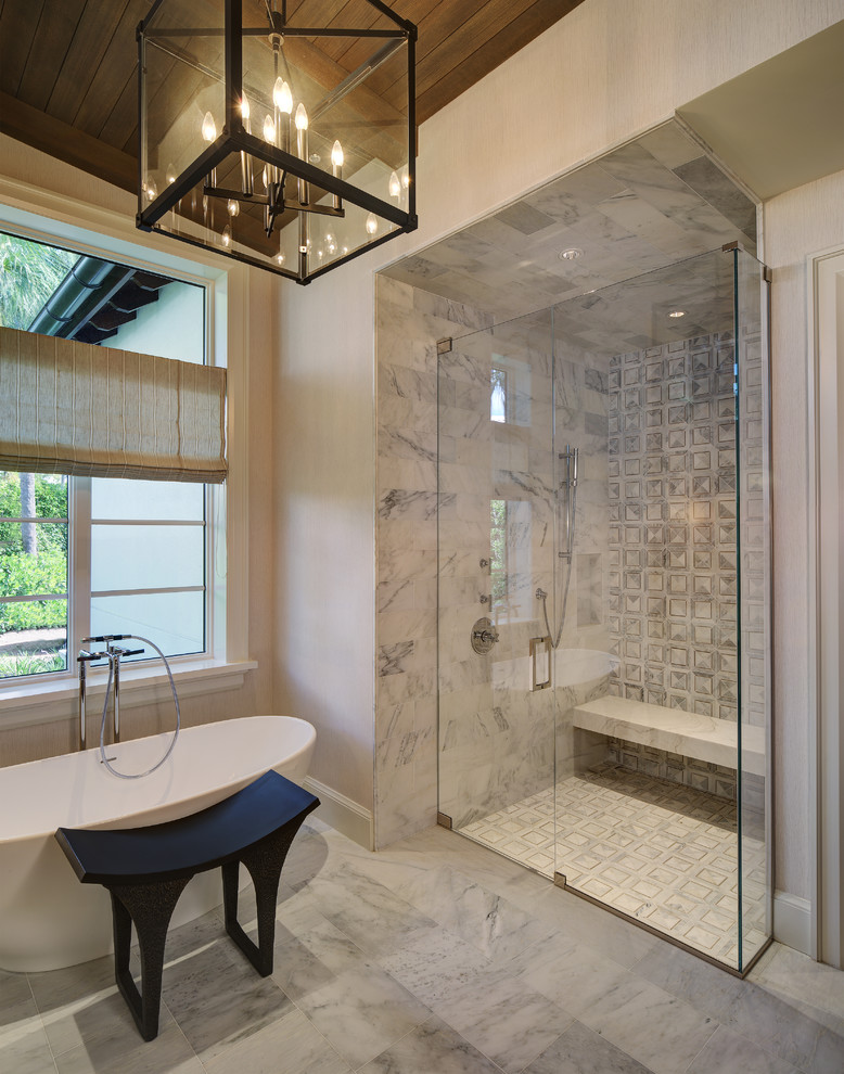 Inredning av ett modernt stort en-suite badrum, med ett fristående badkar, en kantlös dusch, marmorgolv och beige väggar
