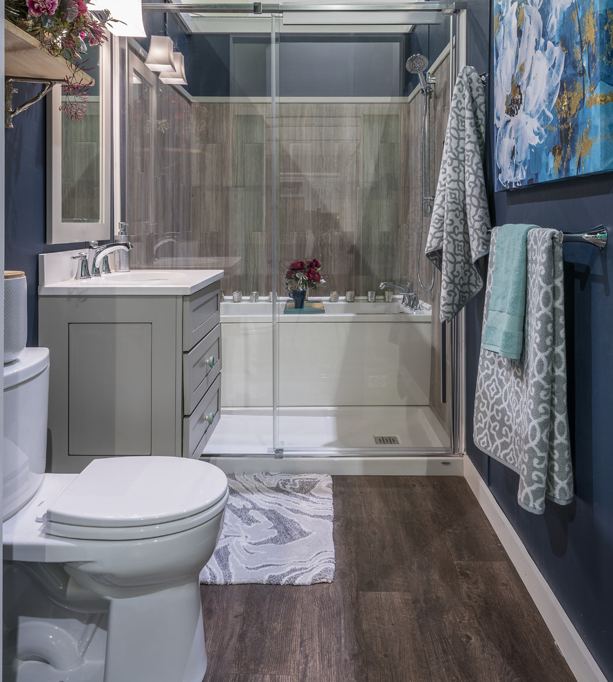 Inredning av ett modernt litet en-suite badrum, med skåp i shakerstil, grå skåp, ett badkar i en alkov, våtrum, en toalettstol med separat cisternkåpa, grå kakel, blå väggar, mörkt trägolv, ett undermonterad handfat, bänkskiva i kvarts och dusch med skjutdörr