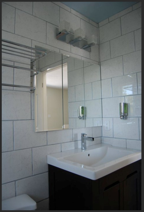 Diseño de cuarto de baño principal marinero pequeño con armarios con paneles empotrados, puertas de armario de madera en tonos medios y encimera de acrílico