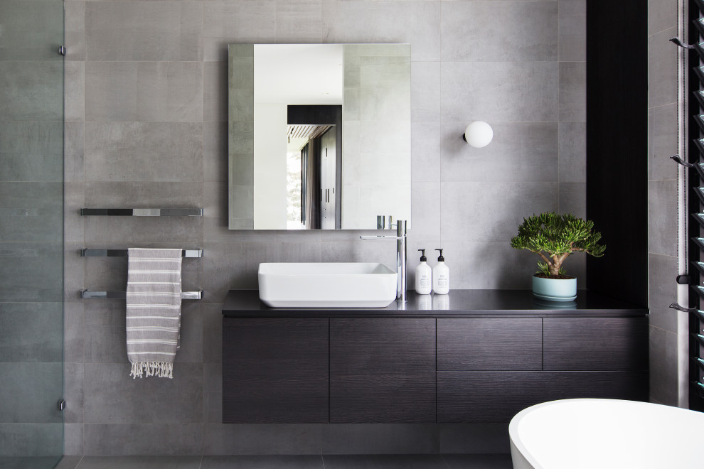Пример оригинального дизайна: главная ванная комната в стиле модернизм с отдельно стоящей ванной, серой плиткой, цементной плиткой, серыми стенами, полом из цементной плитки и серым полом
