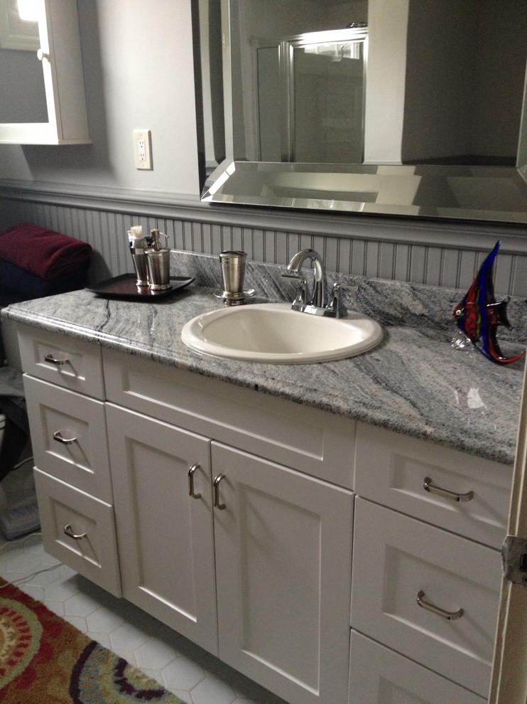 Modern inredning av ett mellanstort badrum med dusch, med ett nedsänkt handfat, skåp i shakerstil, vita skåp, granitbänkskiva och vit kakel