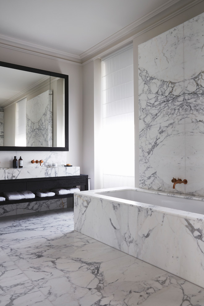 Exemple d'une grande salle de bain tendance avec une baignoire posée, du carrelage en marbre, un sol en marbre, un lavabo suspendu et un plan de toilette en marbre.