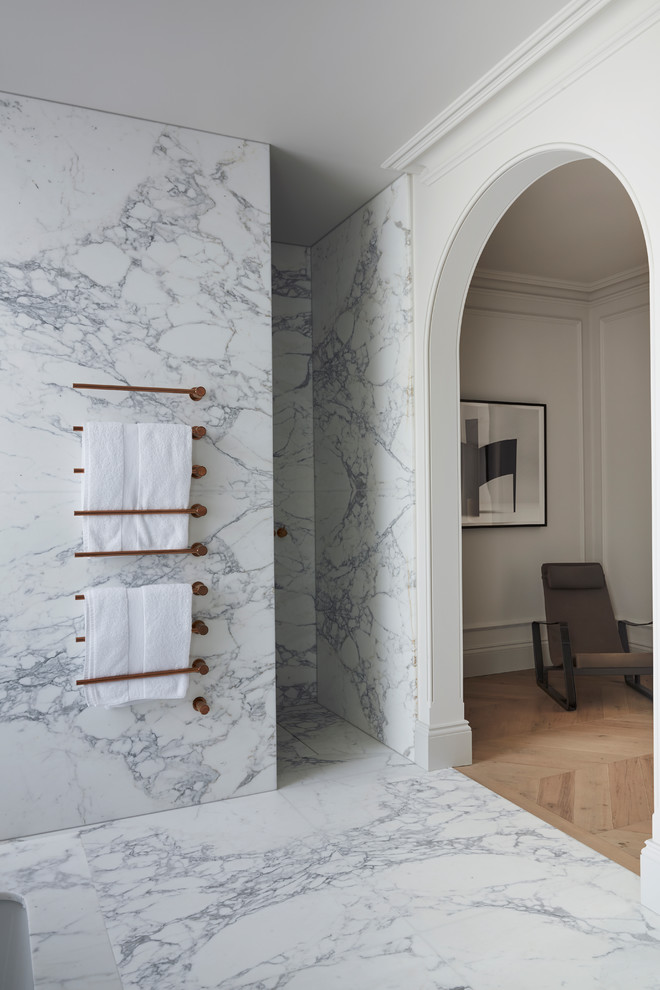 Ispirazione per una grande stanza da bagno minimal con vasca da incasso, piastrelle di marmo, pavimento in marmo, lavabo sospeso e top in marmo