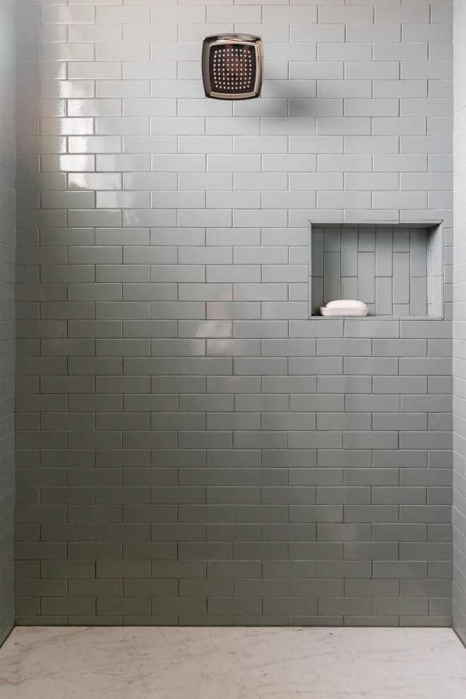 На фото: большая главная ванная комната в стиле неоклассика (современная классика) с серыми фасадами, отдельно стоящей ванной, душевой комнатой, серой плиткой, керамической плиткой, серыми стенами, кирпичным полом, накладной раковиной, бежевым полом, душем с распашными дверями, белой столешницей, нишей и тумбой под две раковины с