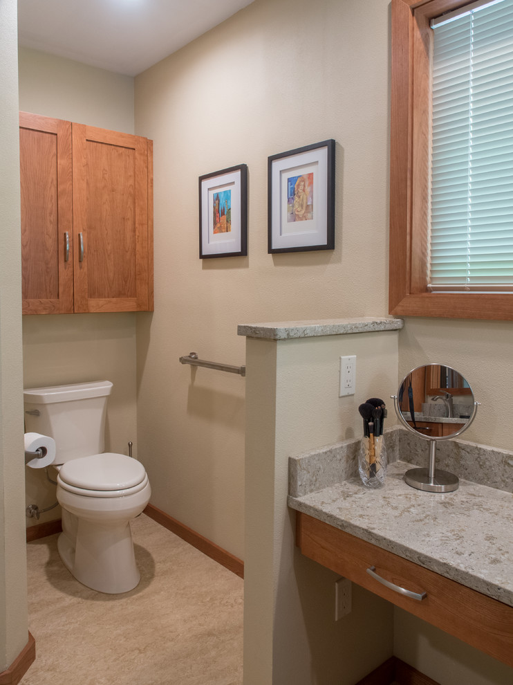 Example of a mid-sized transitional beige tile and porcelain tile linoleum floor and beige floor powder room design in Seattle with an undermount sink, recessed-panel cabinets, medium tone wood cabinets, quartz countertops, a two-piece toilet, beige walls, gray countertops and a built-in vanity