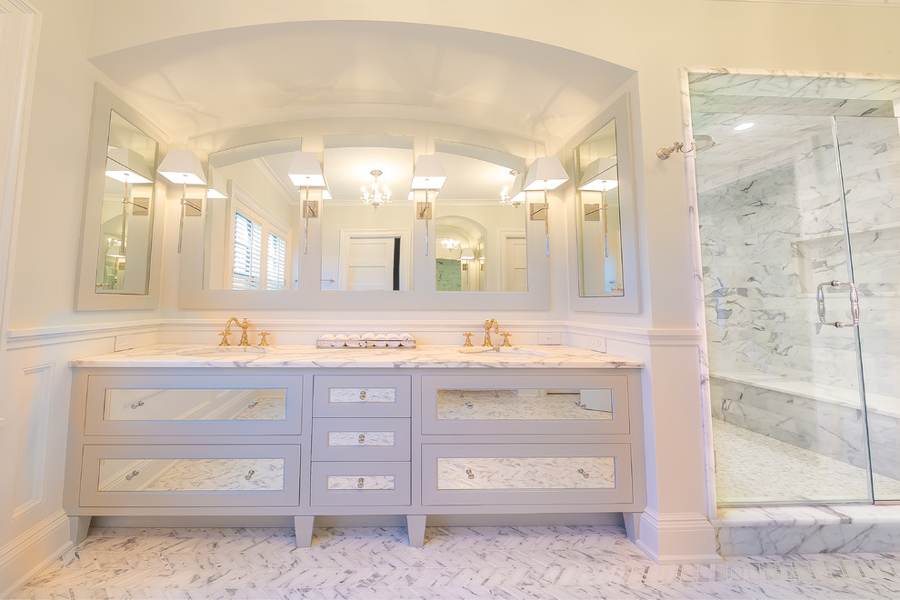 This is an example of a medium sized contemporary ensuite bathroom in New York with shaker cabinets, white cabinets, an alcove shower, white walls, marble flooring, a submerged sink and marble worktops.