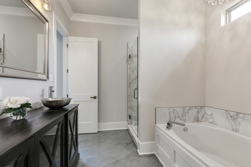 Bathroom - mid-sized transitional master gray tile and marble tile concrete floor and gray floor bathroom idea in New Orleans with furniture-like cabinets, brown cabinets, a two-piece toilet, beige walls, a vessel sink, wood countertops, a hinged shower door and brown countertops