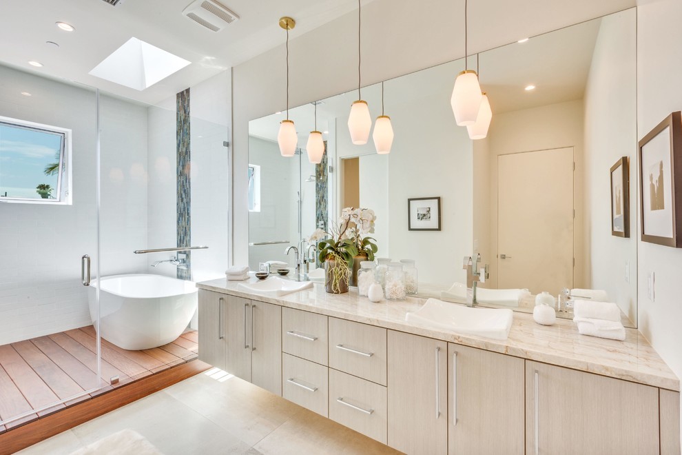 На фото: большая главная ванная комната в современном стиле с накладной раковиной, плоскими фасадами, серыми фасадами, отдельно стоящей ванной, душем в нише, белой плиткой, бежевыми стенами и окном с