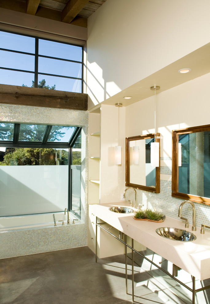 На фото: ванная комната: освещение в современном стиле с накладной раковиной, накладной ванной, плиткой мозаикой и бетонным полом с