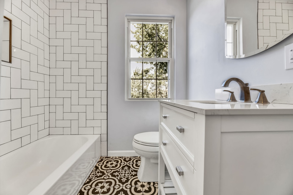 Example of a mid-sized trendy white tile and subway tile porcelain tile and multicolored floor bathroom design in Baltimore with open cabinets, white cabinets, a two-piece toilet, blue walls, a drop-in sink, marble countertops and white countertops