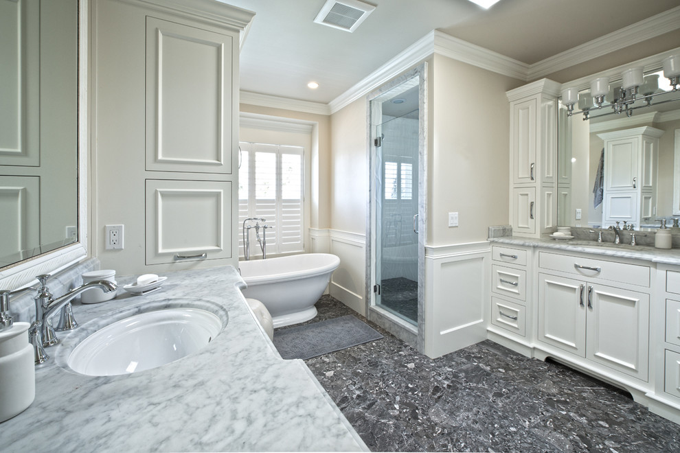 Источник вдохновения для домашнего уюта: большая главная ванная комната в стиле неоклассика (современная классика) с врезной раковиной, фасадами с утопленной филенкой, белыми фасадами, мраморной столешницей, отдельно стоящей ванной, угловым душем, унитазом-моноблоком, разноцветной плиткой и белыми стенами