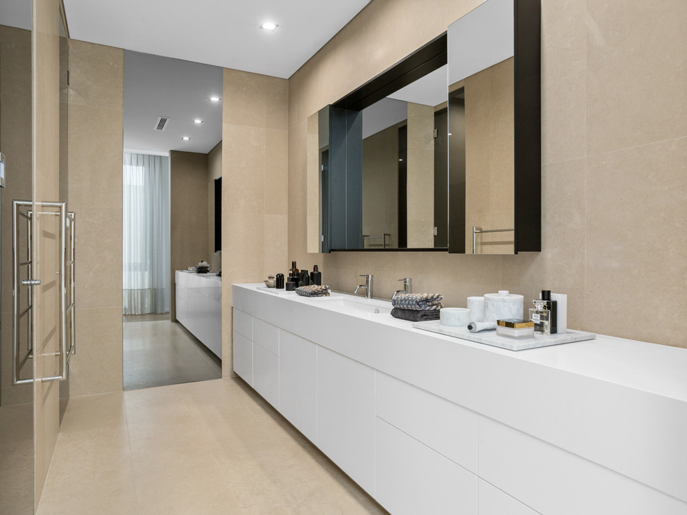 На фото: ванная комната в современном стиле с плоскими фасадами, белыми фасадами, бежевой плиткой, бежевыми стенами, врезной раковиной и бежевым полом
