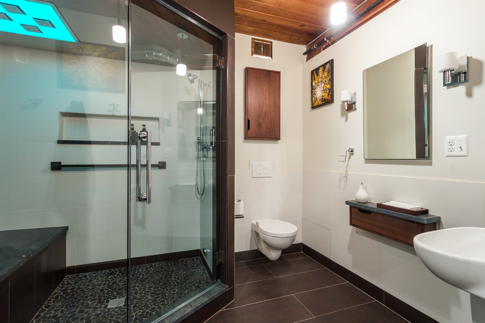 Cette photo montre un sauna industriel en bois brun de taille moyenne avec un placard à porte plane, WC suspendus, un carrelage multicolore, une plaque de galets, un mur blanc, un sol en carrelage de céramique, un lavabo suspendu et un plan de toilette en quartz modifié.