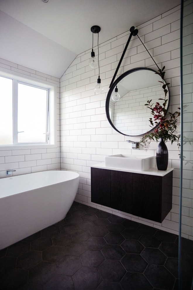 Inspiration för ett funkis vit vitt en-suite badrum, med släta luckor, svarta skåp, ett fristående badkar, en kantlös dusch, vit kakel, vita väggar, ett fristående handfat, svart golv och med dusch som är öppen