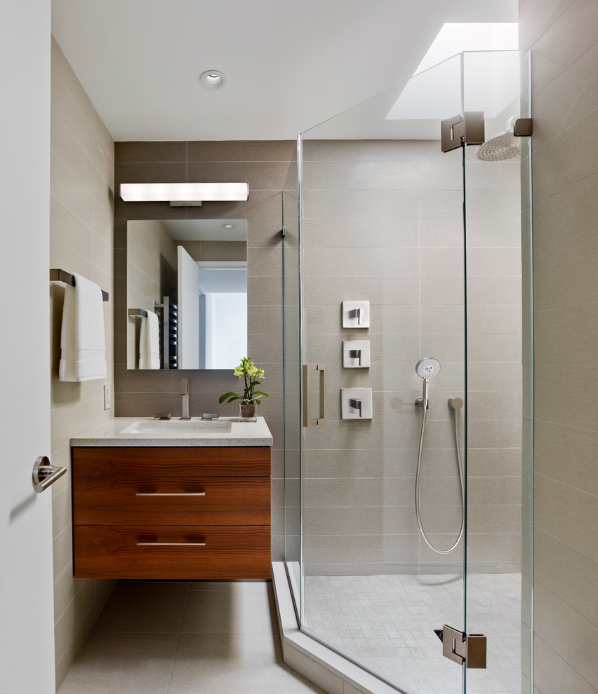 Trendy gray tile and porcelain tile porcelain tile and beige floor corner shower photo in Philadelphia with an undermount sink, flat-panel cabinets, medium tone wood cabinets, quartz countertops, beige walls and a hinged shower door