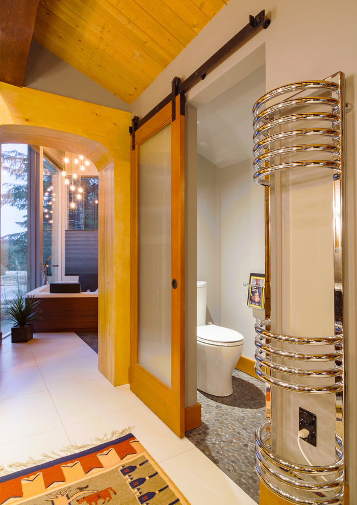 Idée de décoration pour une très grande salle de bain principale minimaliste en bois brun avec un placard à porte plane, une baignoire indépendante, une douche ouverte, un carrelage gris, une plaque de galets, un mur gris, un sol en carrelage de porcelaine, un lavabo encastré et un plan de toilette en marbre.