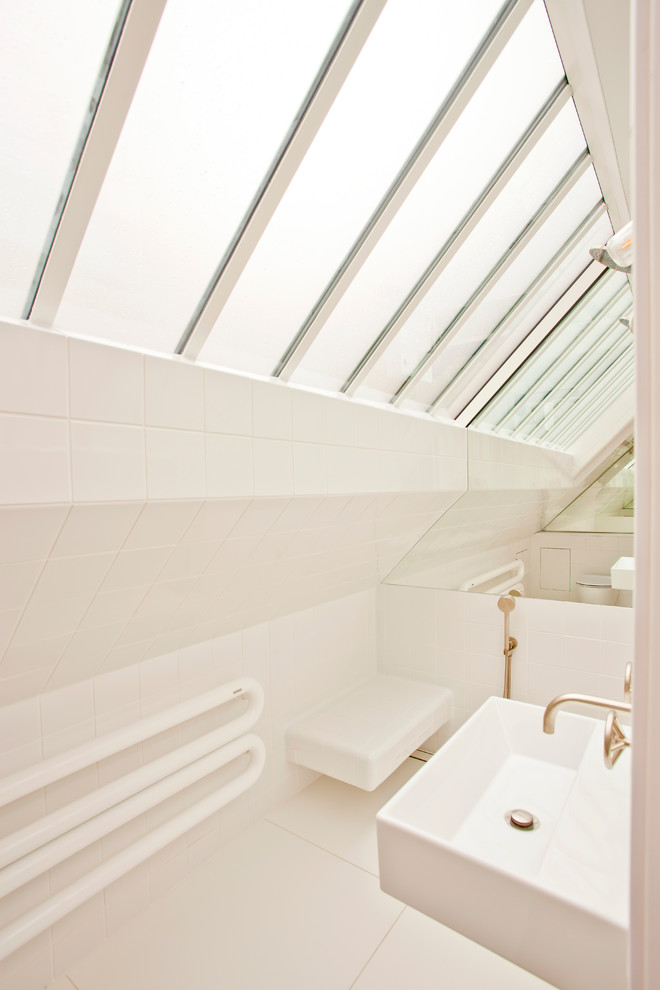 Inspiration för små moderna badrum med dusch, med våtrum, en vägghängd toalettstol, vit kakel, keramikplattor, vita väggar, klinkergolv i porslin, ett väggmonterat handfat och vitt golv