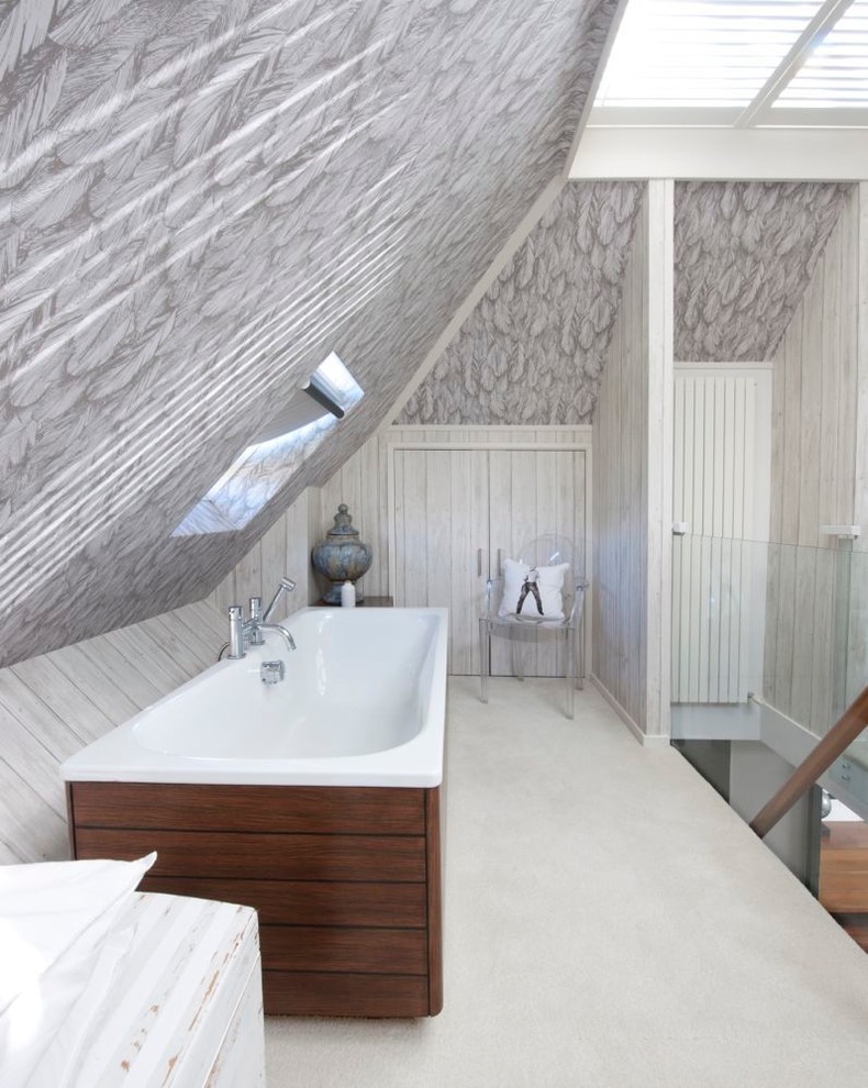 Diseño de cuarto de baño minimalista con bañera encastrada y paredes grises