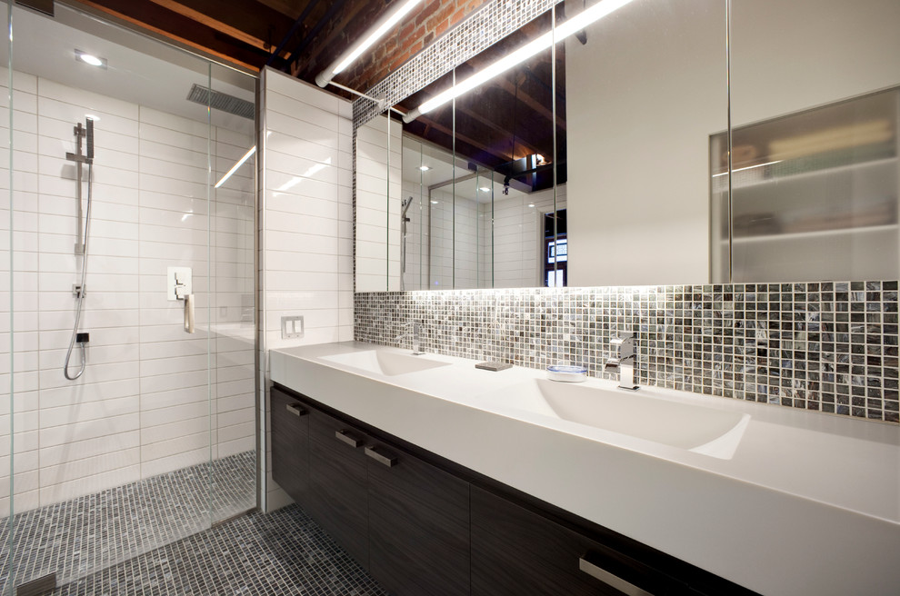 На фото: ванная комната в современном стиле с монолитной раковиной, плоскими фасадами, темными деревянными фасадами, душем в нише и черной плиткой с
