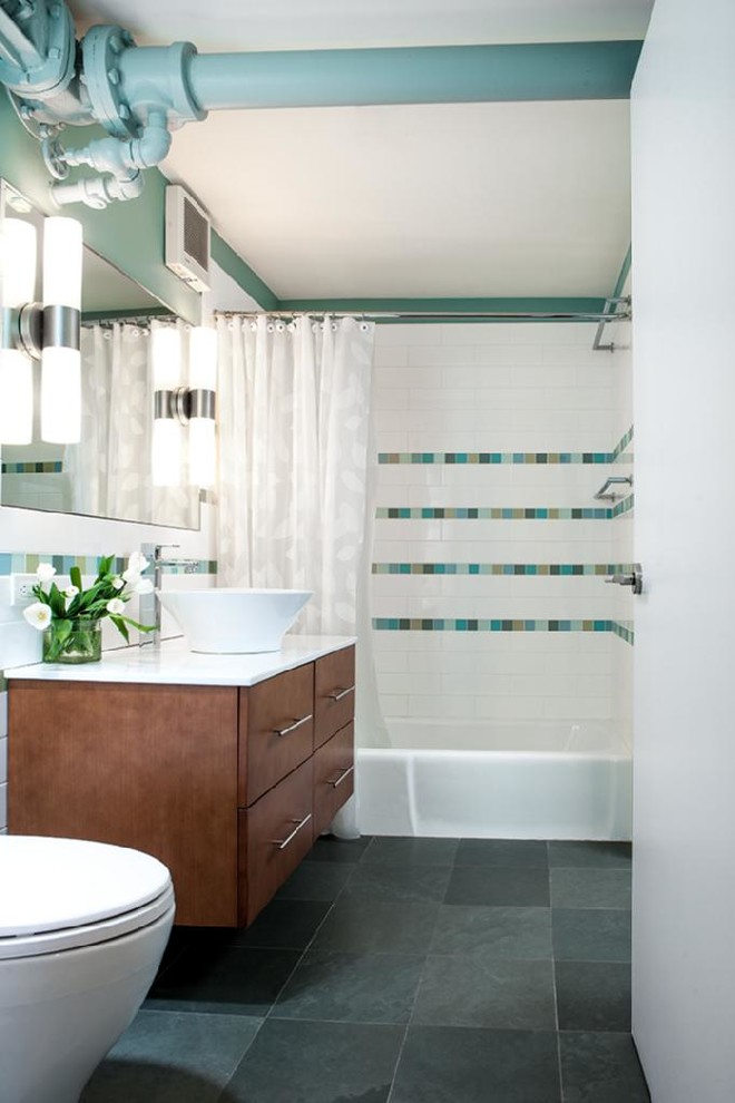 Foto di una stanza da bagno con doccia design di medie dimensioni con ante lisce, ante in legno scuro, vasca ad alcova, vasca/doccia, piastrelle multicolore, pareti blu e lavabo a bacinella