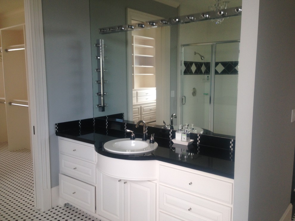 Design ideas for a medium sized traditional ensuite bathroom in Houston with raised-panel cabinets, white cabinets, an alcove shower, black and white tiles, porcelain tiles, grey walls, mosaic tile flooring, a built-in sink, granite worktops, multi-coloured floors and a hinged door.