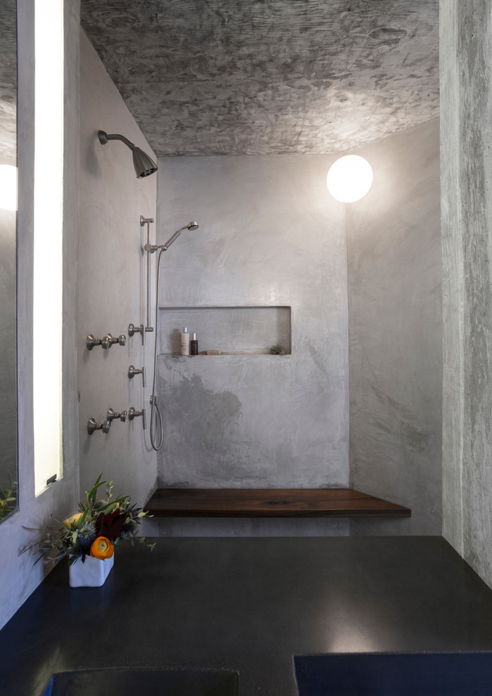 Cette image montre une petite salle de bain principale urbaine en bois foncé avec un lavabo intégré, un placard à porte plane, un plan de toilette en béton, une douche ouverte, WC suspendus et sol en béton ciré.