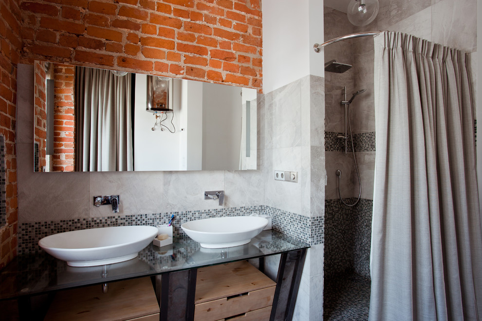 На фото: ванная комната в стиле лофт с душем в нише, серой плиткой, серыми стенами, душевой кабиной и настольной раковиной