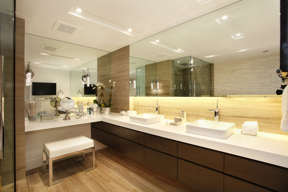 Стильный дизайн: ванная комната в современном стиле с настольной раковиной, плоскими фасадами, темными деревянными фасадами, столешницей из искусственного кварца, отдельно стоящей ванной и плиткой из листового камня - последний тренд