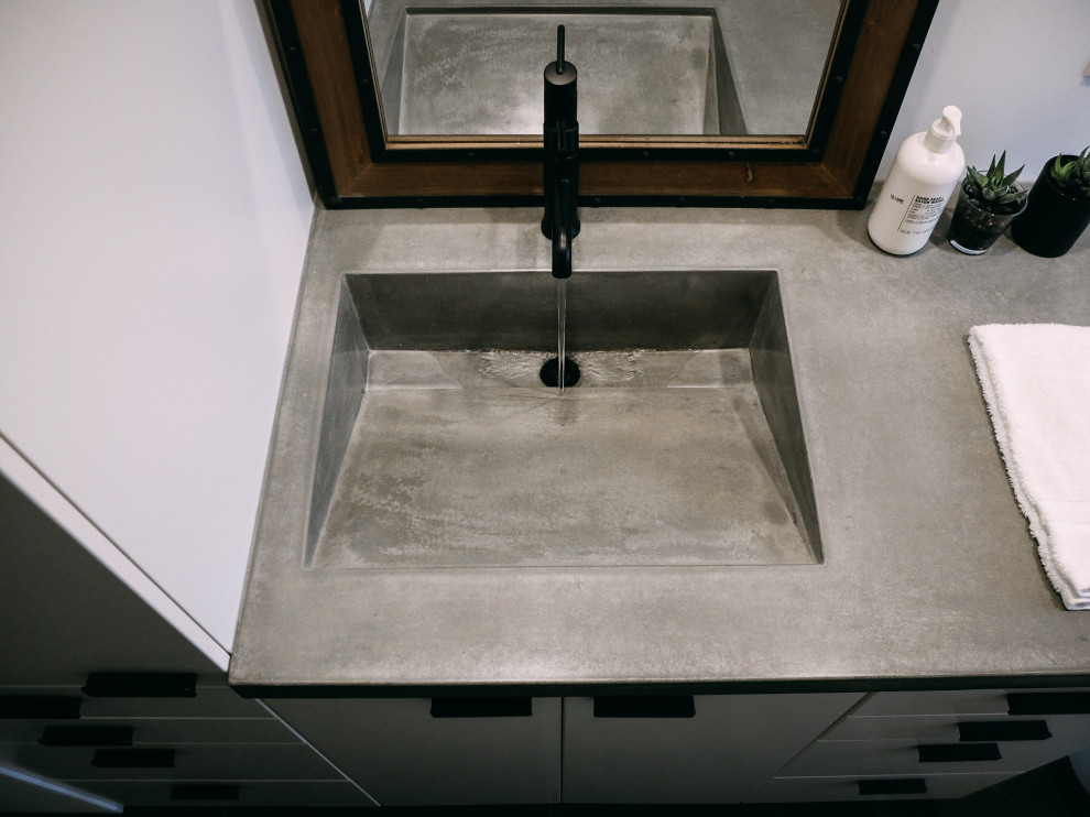 Mid-sized 1950s master single-sink bathroom photo in Toronto with flat-panel cabinets, white cabinets, an integrated sink, concrete countertops, gray countertops and a built-in vanity