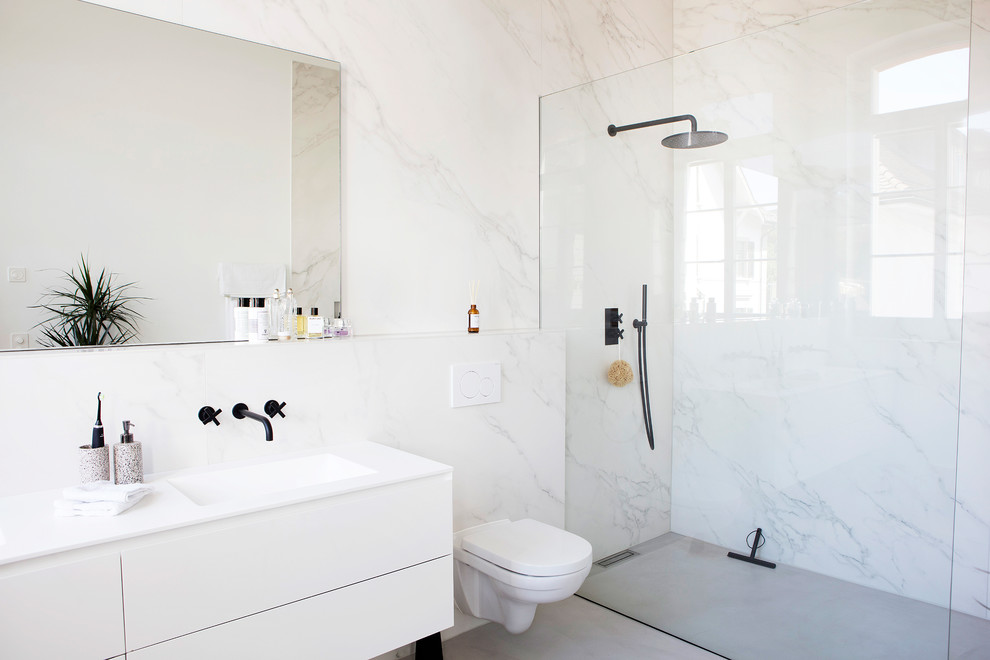 На фото: ванная комната в стиле модернизм с плоскими фасадами, белыми фасадами, угловым душем, унитазом-моноблоком, серой плиткой, белой плиткой, белыми стенами, душевой кабиной, врезной раковиной, серым полом и открытым душем