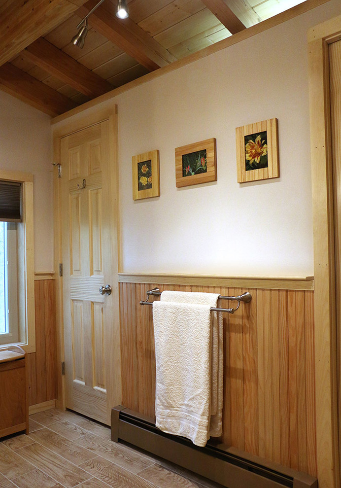 Ejemplo de cuarto de baño principal rústico de tamaño medio con armarios con paneles lisos, puertas de armario de madera clara, ducha esquinera, sanitario de una pieza, paredes beige y suelo de madera clara
