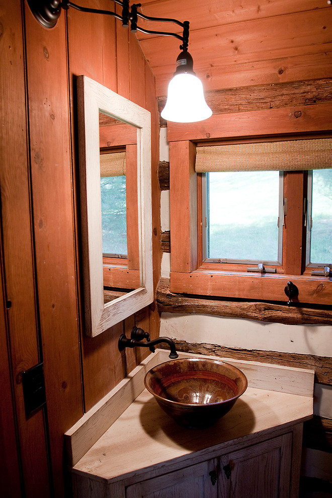 Inspiration pour une petite salle de bain rustique en bois vieilli avec une vasque, un placard à porte plane et un plan de toilette en bois.