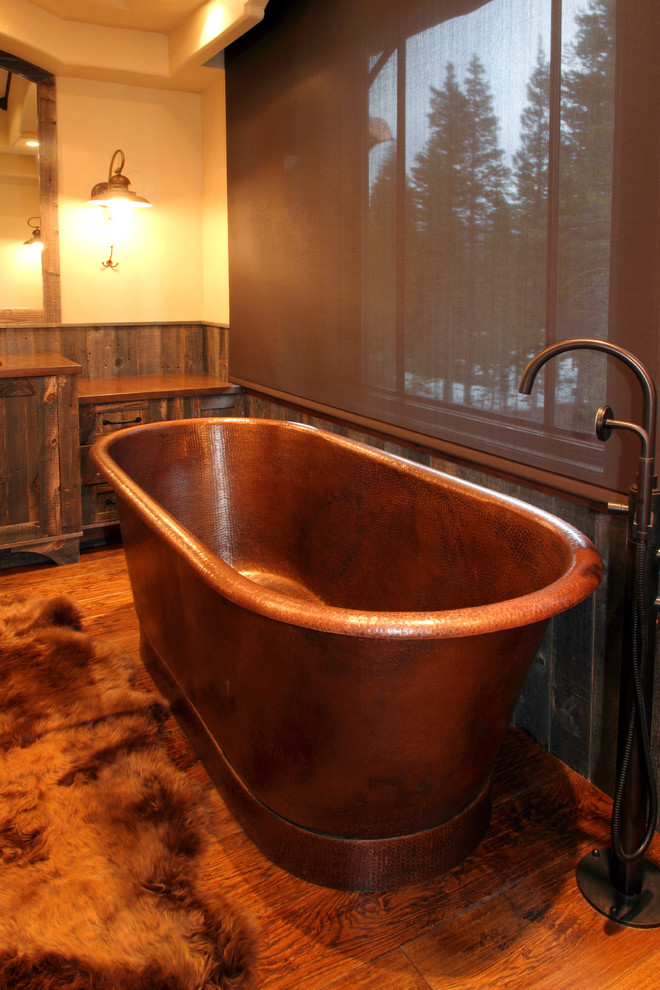 Inspiration pour une grande salle de bain principale chalet en bois brun avec un lavabo encastré, une baignoire indépendante, un mur beige, un sol en bois brun, un placard à porte shaker et un plan de toilette en cuivre.