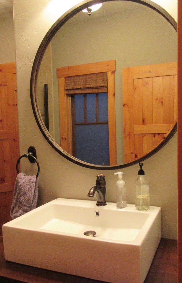 Kleines Rustikales Duschbad mit braunen Schränken, Duschnische, Wandtoilette mit Spülkasten, grauer Wandfarbe, Backsteinboden, Aufsatzwaschbecken, Waschtisch aus Holz, buntem Boden und Falttür-Duschabtrennung in San Francisco