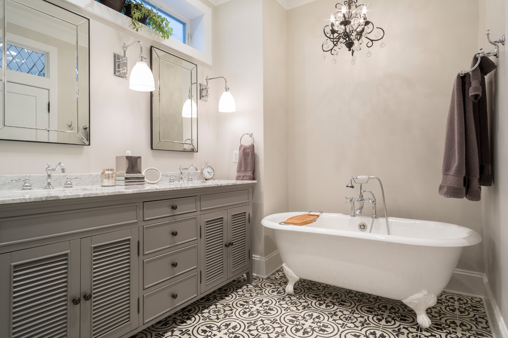 Bild på ett mellanstort vintage grå grått en-suite badrum, med grå skåp, ett badkar med tassar, grå väggar, cementgolv, ett undermonterad handfat, marmorbänkskiva, flerfärgat golv och luckor med lamellpanel