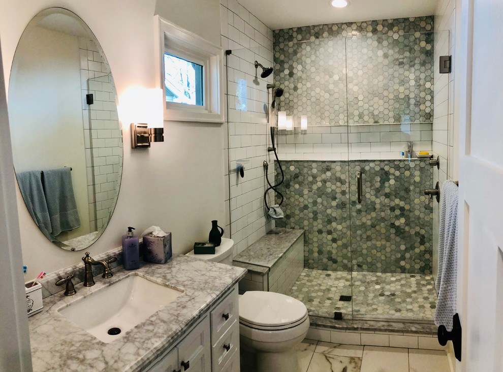 Alcove shower - craftsman master white tile and marble tile marble floor and white floor alcove shower idea in Charlotte with furniture-like cabinets, white cabinets, a one-piece toilet, white walls, an undermount sink, marble countertops, a hinged shower door and white countertops