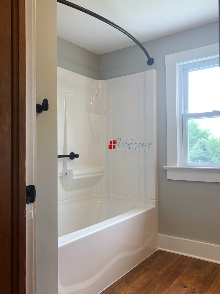 Aménagement d'une petite salle de bain montagne en bois brun avec un placard à porte shaker, un combiné douche/baignoire, WC séparés, un mur bleu, un sol en vinyl, un lavabo intégré, une cabine de douche avec un rideau et un plan de toilette blanc.