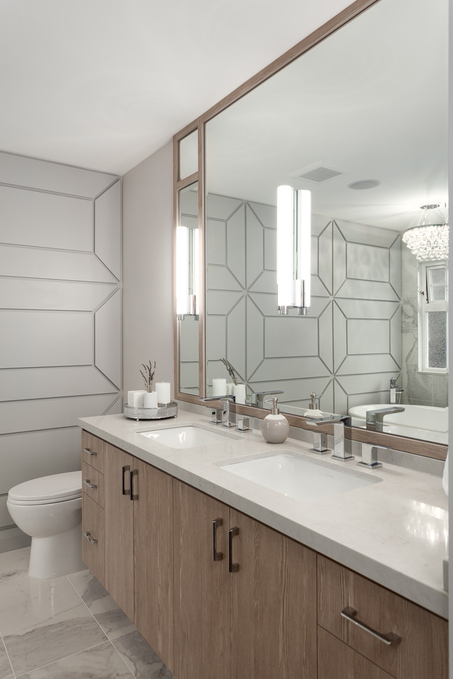 Mid-sized trendy master marble tile white floor and marble floor bathroom photo in Vancouver with flat-panel cabinets, gray walls, an undermount sink, medium tone wood cabinets and solid surface countertops